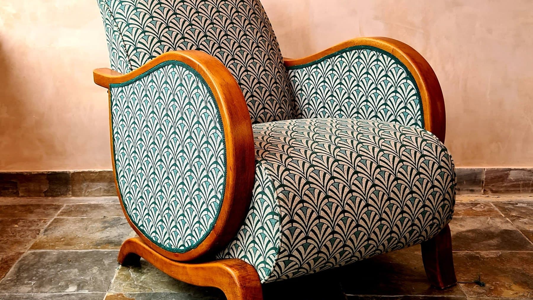 Joseph Legoff's recliner after Valérie Hayes restored it, in a geometric green and cream fabric with polished wooden arms